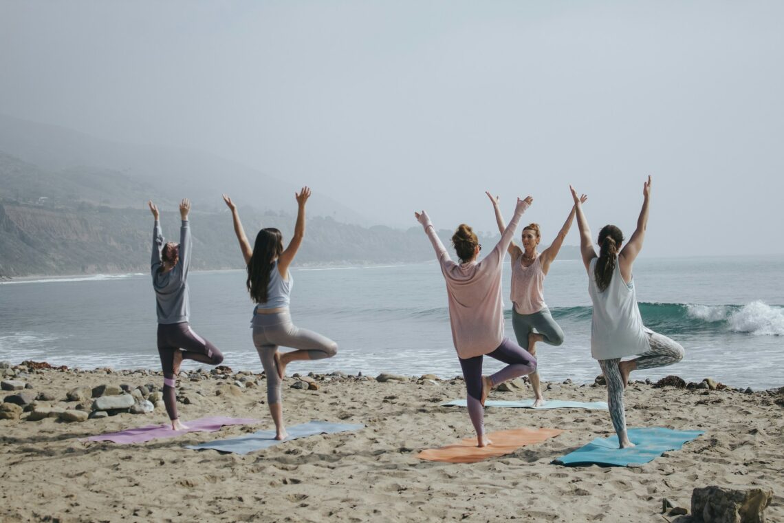 People on the beach doing yoga