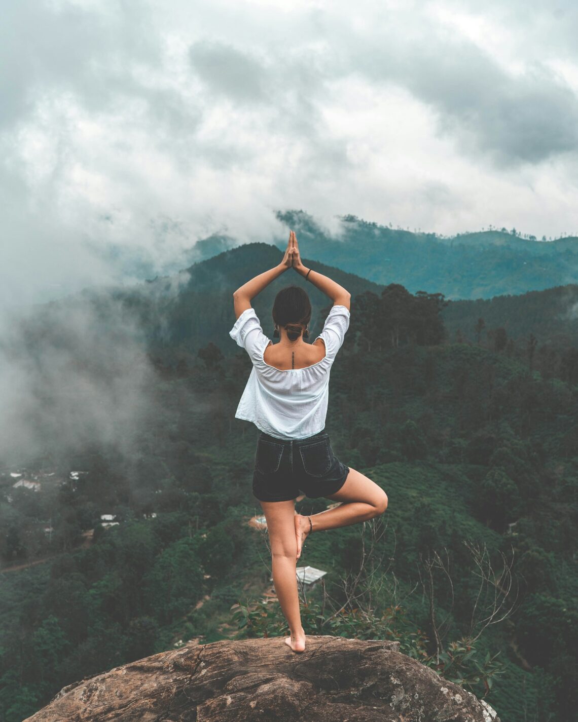 Girl on a mountain in Yoga tree pose