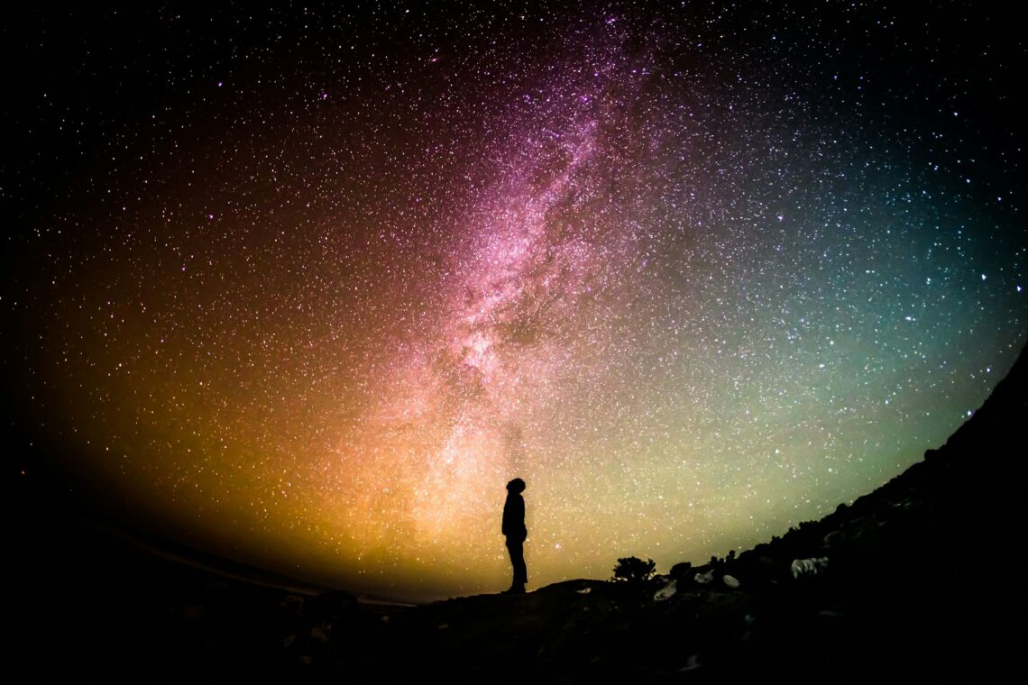 Person standing in a galaxy of stars