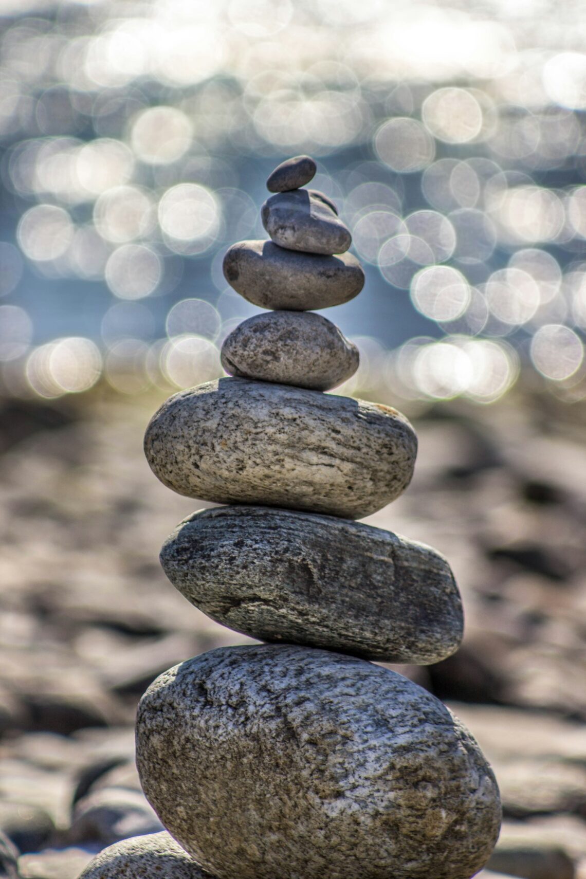 Stones stacked in a tower style with beach in the background