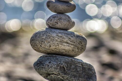 Stones stacked in a tower style with beach in the background