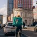 Delivery rider in city traffic with building and cars surrounding