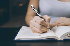 Person writing in a note book