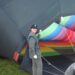 Girl pilot next to a hot air balloon inflating