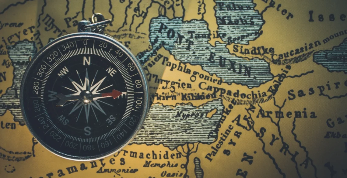 compass on an antique map of the world