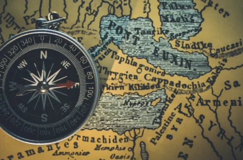 compass on an antique map of the world