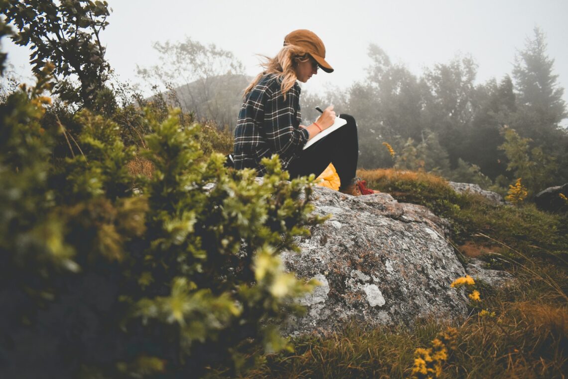 Girl in nature writing in a diary